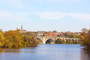 A view on Key Bridge and historic buildings across Potomac River in autumn. Fall colors of Potomac riverside at Georgetown suburb of Washington DC, USA.
