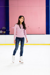 Asian woman skating on ice rink