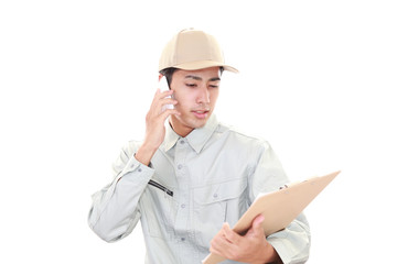 スマートフォンで通話中の労働者