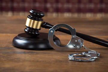 Mallet And Handcuffs On Table In Courtroom