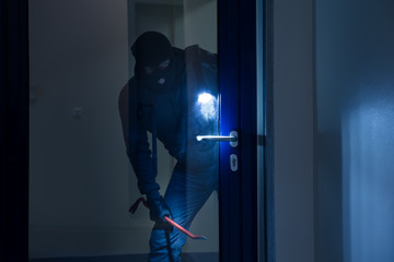 Thief With Flashlight Trying To Break Door - obrazy, fototapety, plakaty