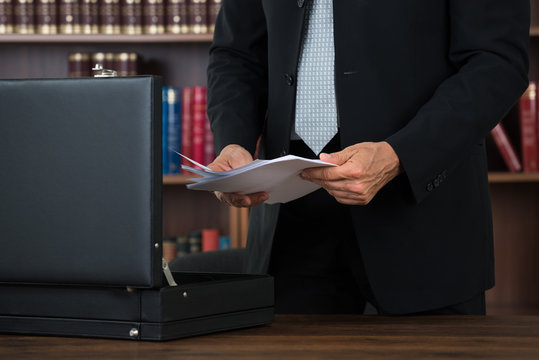 Lawyer Keeping Documents In Briefcase In Office