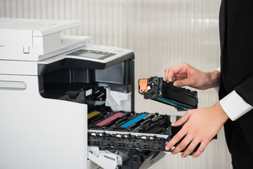 Businessman Fixing Cartridge In Printer Machine At Office - obrazy, fototapety, plakaty