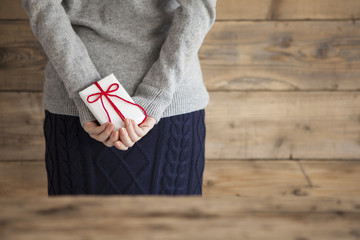Women have hidden a gift box with a hand behind
