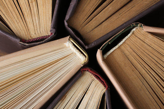 the book with the colored cover lay open on a wooden table