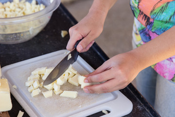 Obraz na płótnie Canvas Woman cutting cheese cooking pizza