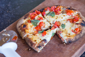 Homemade baked pizza on wooden cutting board