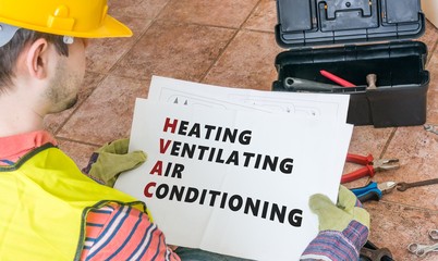 Repairman is looking at documentation of HVAC (Heating, Ventilating, Air Conditioning)