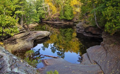 Naklejka na ściany i meble Autumn Reflections. Fall colors reflected in a lagoon in the Porcupine Mountains State Park in Michigan's Upper Peninsula wilderness