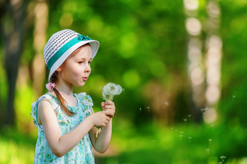 Little girl blowing dandelion
