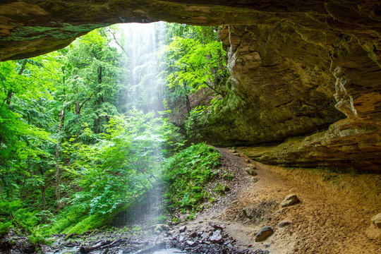 Fototapeta Grotto Waterfall. Memorial Falls illuminated by the sunlight as seen from the grotto behind the waterfall. Munising, Michigan.