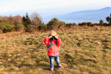 Naklejka na ściany i meble little tourist with binoculars travel in mountains