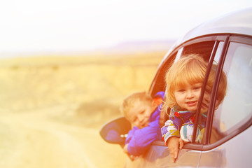 Fototapeta na wymiar little girl and boy travel by car in mountains
