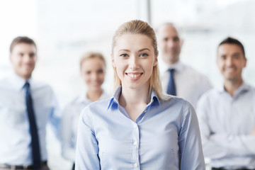 smiling businesswoman with colleagues in office