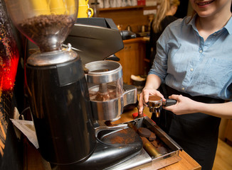 Fototapeta na wymiar close up of woman making coffee by machine at cafe