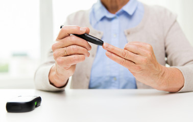 senior woman with glucometer checking blood sugar