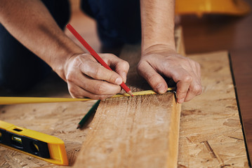 Craftsman measuring wooden plank with ruler on the floor. Concept of diy, woodworking and home renovation.  - 101369928