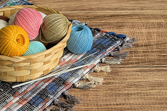 Yarn.  Balls of colored cotton yarn in a basket on a brown wooden background.
 