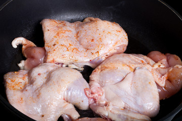 Chicken with spices fried in a pan