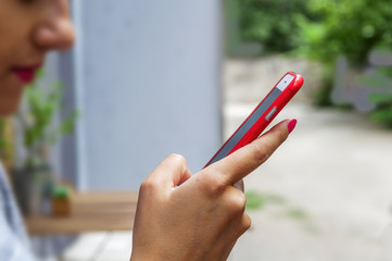 Trendy young woman use a smart phone in coffee shop blur