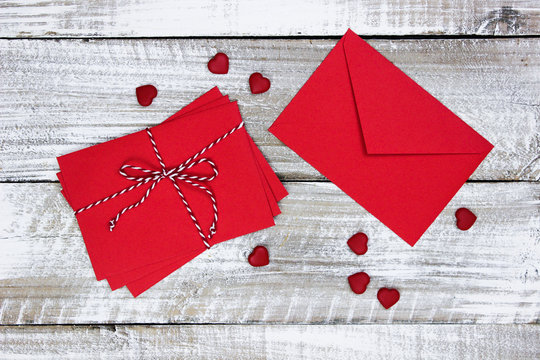 Red envelopes and hearts on white wood background - Powered by Adobe