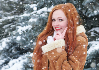 Fototapeta premium Winter woman outdoor portrait, smiling and show finger