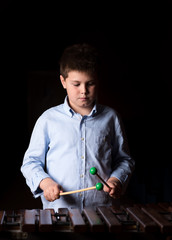 Boy playing on xylophone