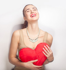 young attractive woman laughing and holding red heart in hands