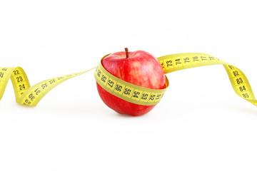 Red apple and measuring metre on a white background