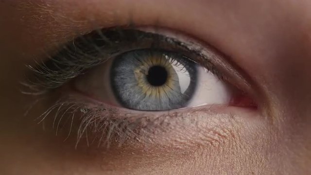 Close-up shot of a woman opening her blue eyes with light day make-up and focusing them. Shot on RED Cinema Camera.