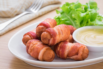 Sausages wrapped with bacon and dipping sauce