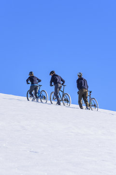 Mountainbiker im Winter beim Aufstieg im Schnee