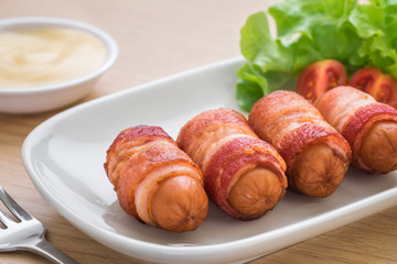 Sausages wrapped with bacon and dipping sauce