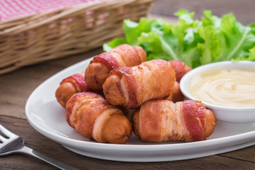 Sausages wrapped with bacon and dipping sauce