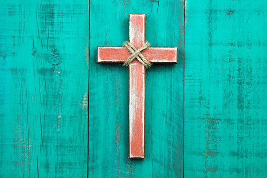 Rustic wood cross hanging on antique green wooden background