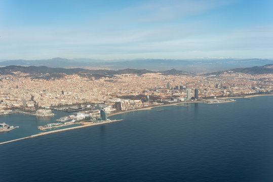 Air image from the city Barcelona with a sea of houses and urban canyons and all the landmarks and monuments. Barcelona is very popular and one of the most densely populated cities in Europe 