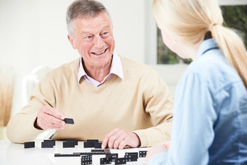 Senior Man Playing Dominoes With Teenage Granddaughter