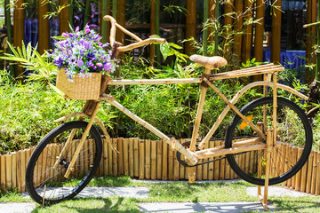 Purple flowers on a bamboo bicycle basket.