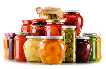 Jars with fruity compotes jams and pickled vegetables isolated