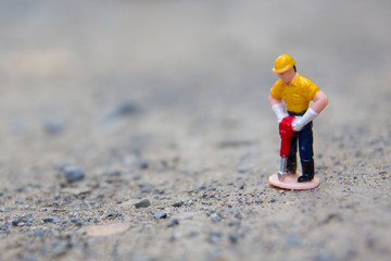 small figure of worker digging concrete. 