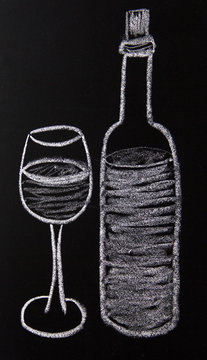 A glass and a bottle of wine painted with chalk