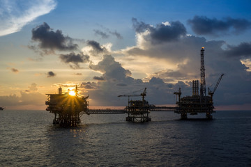 Offshore oil rigs or production platforms during sunset