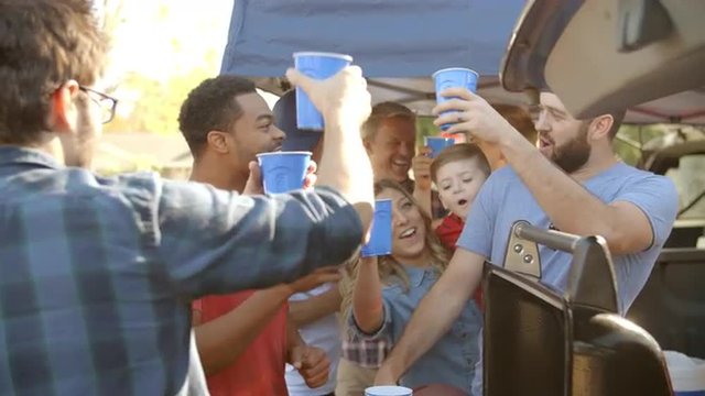Slow Motion Shot Of Sports Fans Tailgating In Parking Lot
