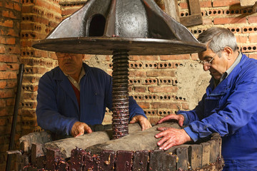 farmers making wine of grape  in traditional winepress  in  Villarejo de Orbigo, Leon, Spain ; slow shutter speed with flash