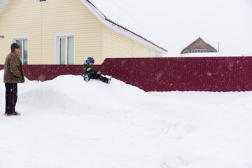 a little boy riding on a snowy hill