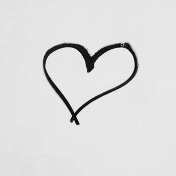 Heart shape sketched on a white wall in black ink