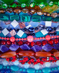Lot of colored beads from different minerals. Stone background