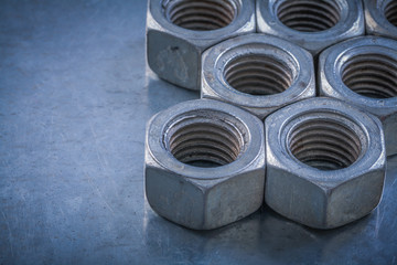 Heap of screw-nuts on metallic background maintenance concept