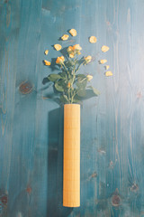 yellow roses on a blue wooden table