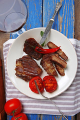 Roasted beef fillet and grilled vegetables on plate, on wooden background